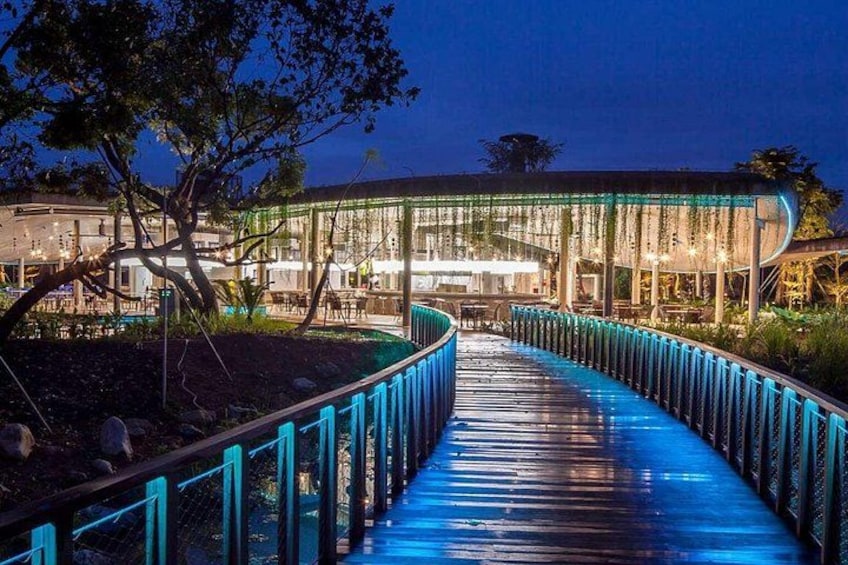 A curved pathway with blue railings leading to a building with a glass facade. 4