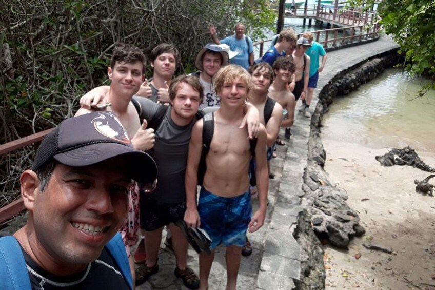 Un gruppo di persone su un ponte di pietra sopra un corso d'acqua circondato da fitta vegetazione. 1