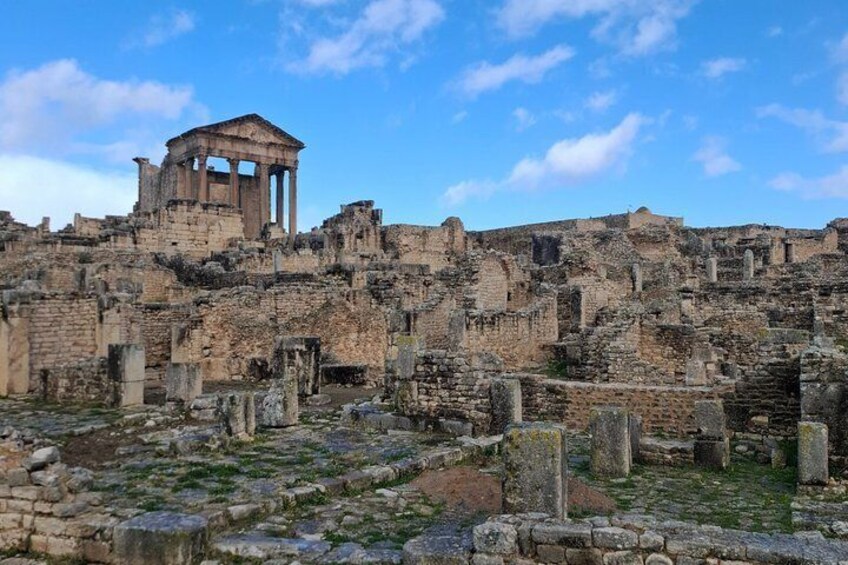Ancient ruins with columns and a temple structure. 3