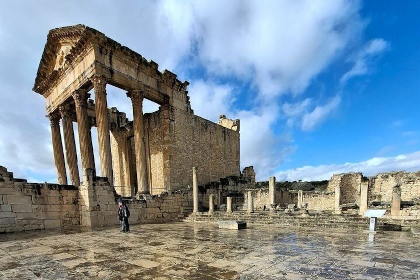 Ancient ruins with columns, a stone floor, and a clear blue sky. 4