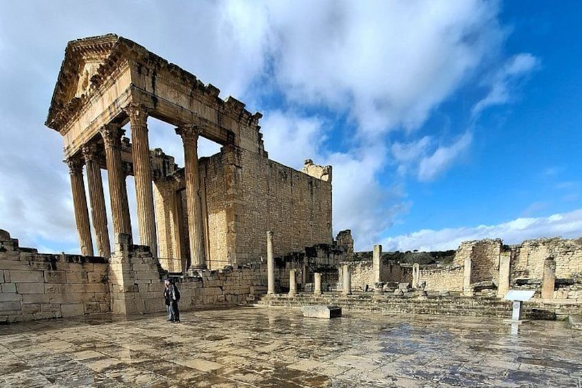 Ancient ruins with columns and a large stone structure. 3