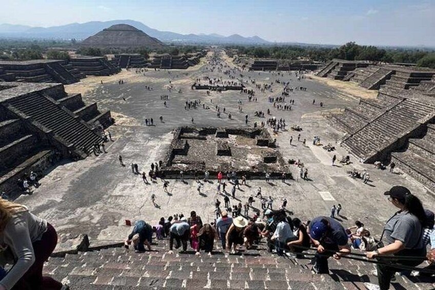 Un antiguo sitio arqueológico con estructuras escalonadas y una gran plaza abierta. 3