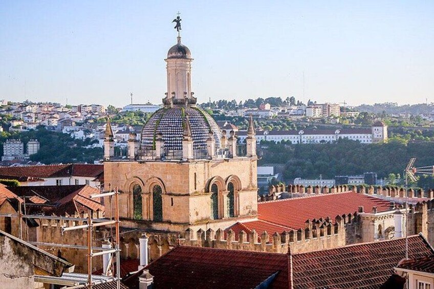 Una iglesia histórica con cúpula y campanario, rodeada de edificios con tejados rojos. 3