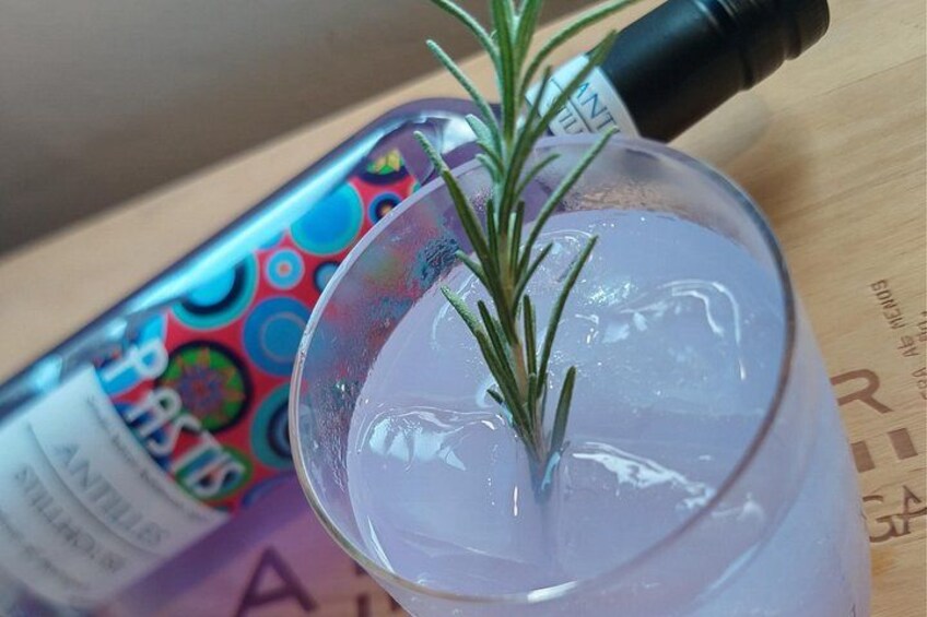 Un vaso transparente con cubitos de hielo y una ramita de romero. 3