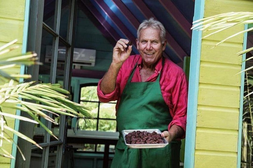 Una persona sostiene un plato de chispas de chocolate, de pie frente a una casa amarilla con una puerta verde. 1