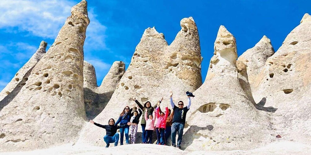 A group of people posing in front of unique rock formations. 1