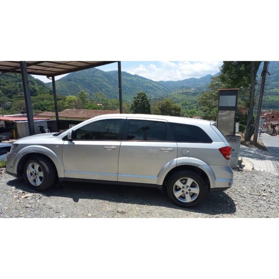 A silver SUV parked at a gas station with a mountainous landscape in the background. 5