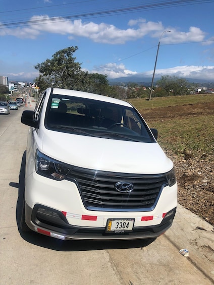 A white Hyundai car parked on a road with a clear sky and distant mountains. 3
