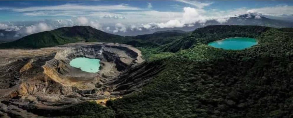 A volcanic crater with a turquoise lake surrounded by lush greenery. 1