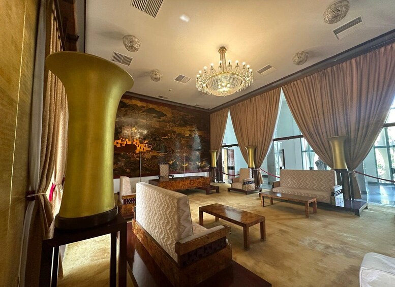 Un lobby lujoso con una gran lámpara de araña, muebles elegantes y una pared decorativa. 5