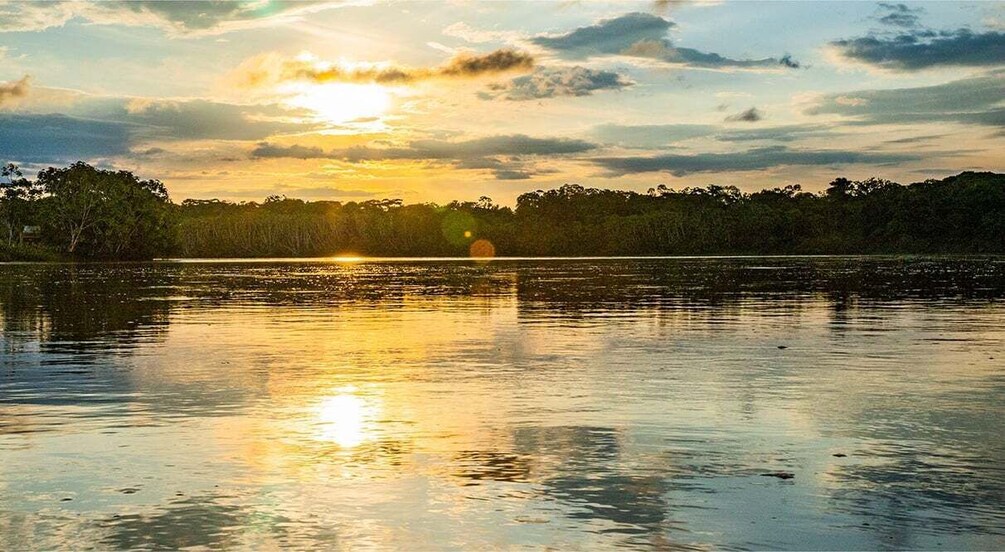 A sunset over a calm lake with reflections of the sky and trees. 5