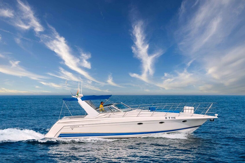 A white yacht with blue stripes named "FORMULA" on the water. 1