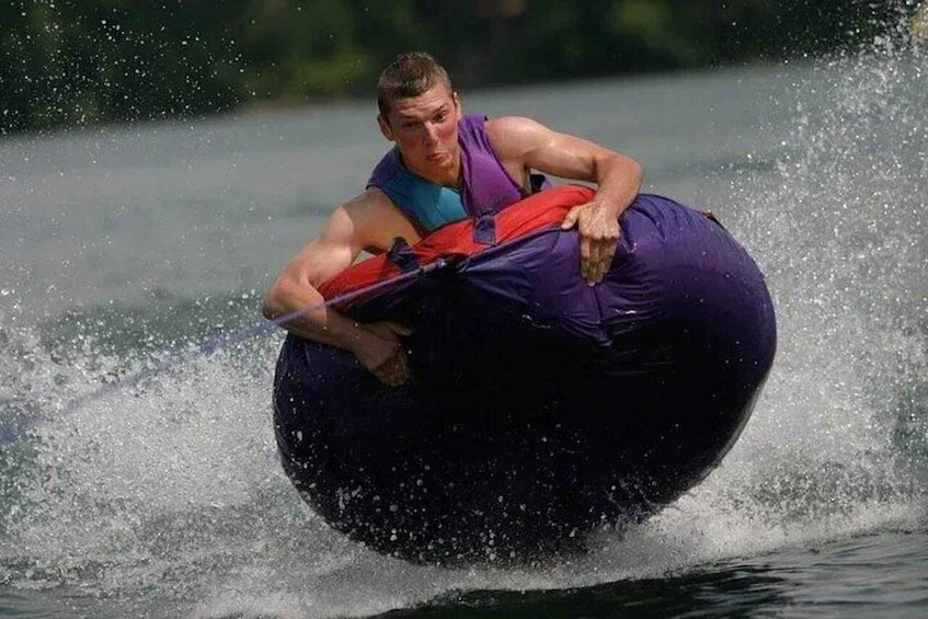 A person water skiing on a large inflatable tube. 1