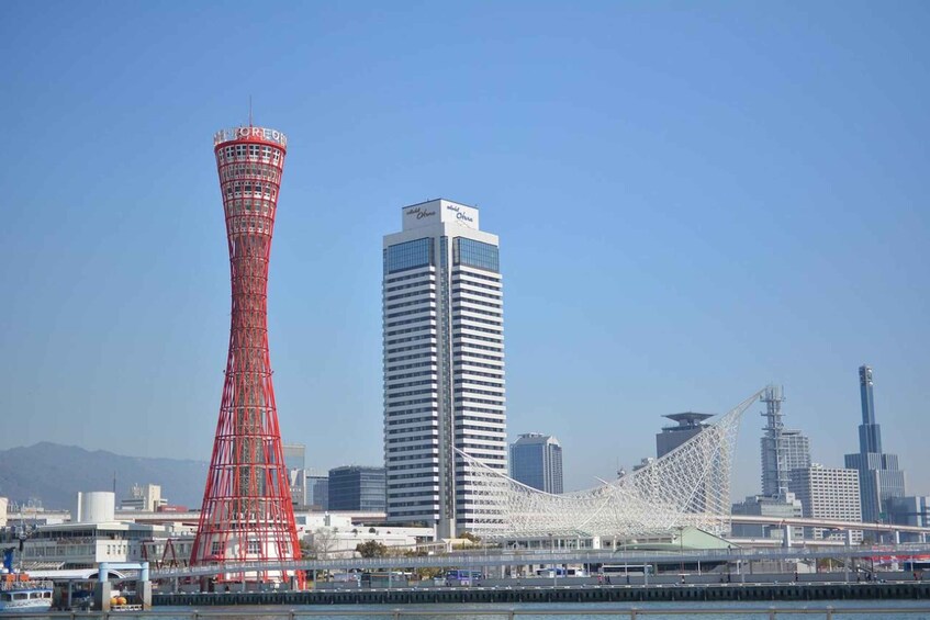 A cityscape with a red tower, a white skyscraper, and a bridge. 5