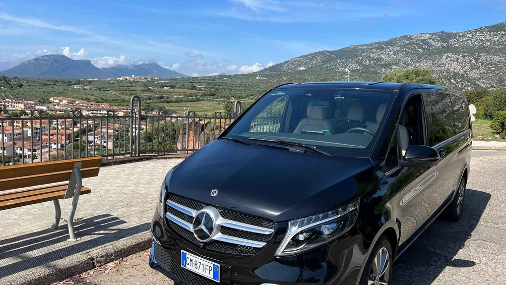 A black Mercedes-Benz SUV parked on a paved area with a scenic mountain view in the background. 5