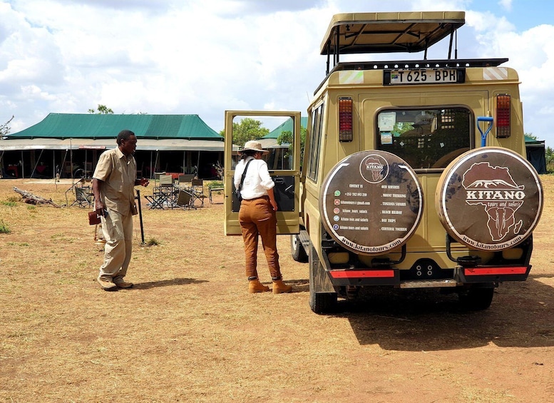 A safari vehicle with a signboard advertising 'Kitano tours and safaris'. 4