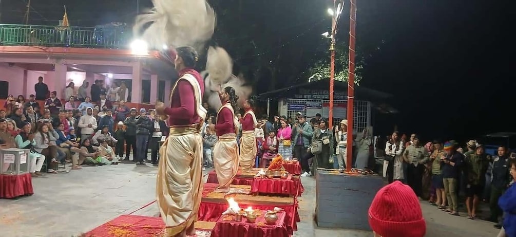 A group of people performing a ritual with incense and offerings on a stage. 1
