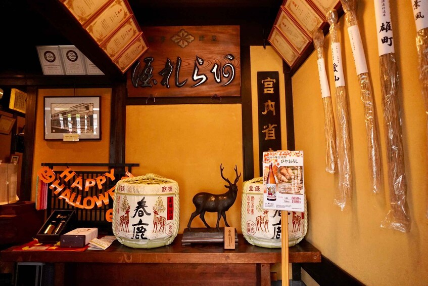 A traditional Japanese shop with wooden signage, a framed picture, and various packaged goods. 3