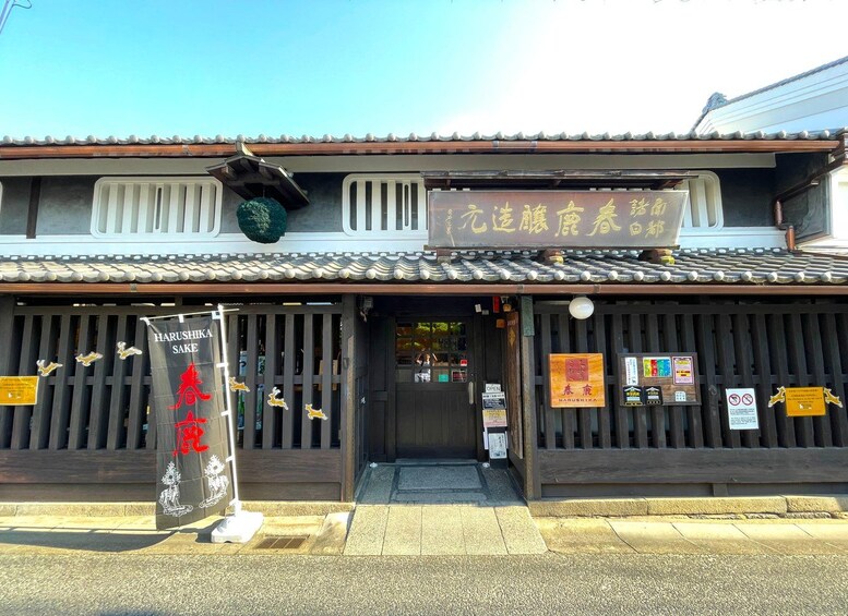 A traditional Japanese building with a signboard and a Harushika Sake sign. 5