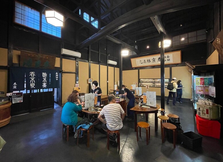 A restaurant interior with tables, chairs, and patrons. 4