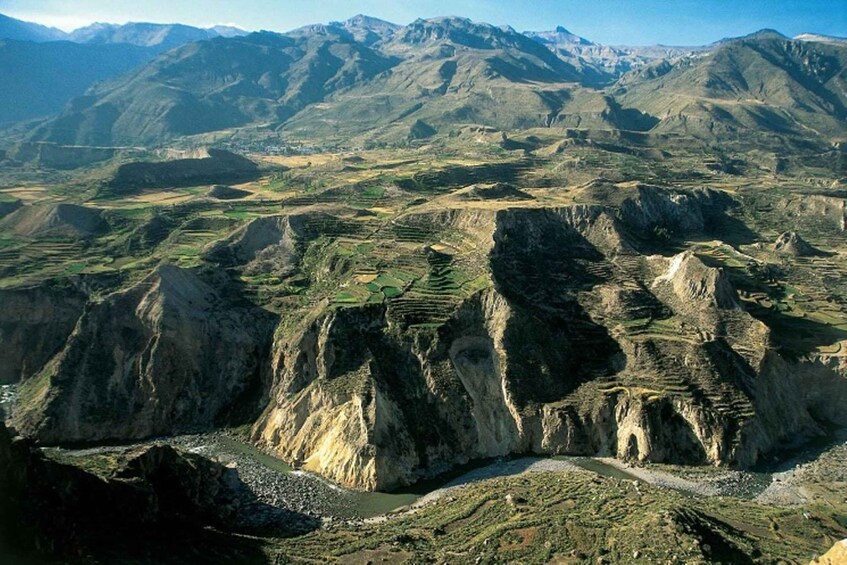 A mountainous landscape with terraced fields and a winding river. 4