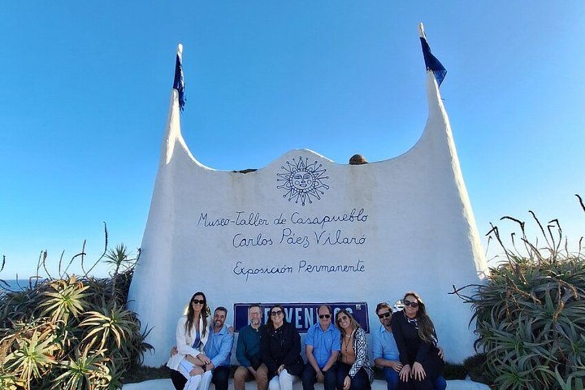 A white monument with flags, featuring the text 'Museo-Taller de Carlos Pizarro' and 'Exposición Permanente.' 4