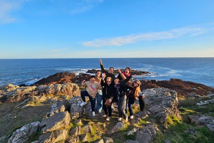 A group of people on rocky terrain by the sea. 2