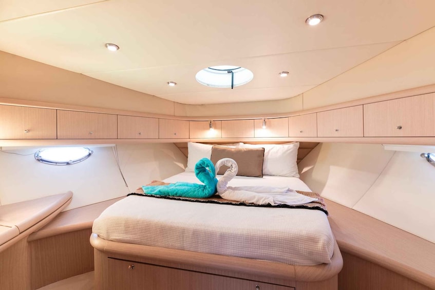 A cozy cabin with a bed, a round skylight, and wooden cabinetry. 2