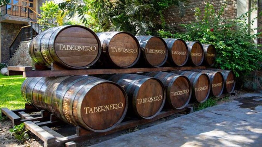 Wooden barrels stacked on a wooden platform outdoors. 4