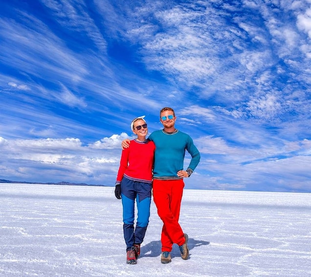 Two people standing on a snowy plain with a clear blue sky. 3