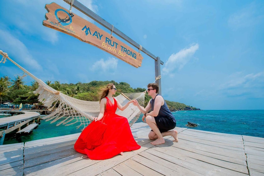 A wooden dock with a sign reading "May Rut Trang Beach Bar". 2