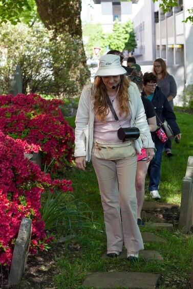 A person walking on a stone path surrounded by vibrant pink flowers and greenery. 5