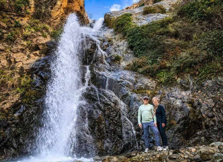 A waterfall cascading down a rocky cliff with vegetation on the sides. 5