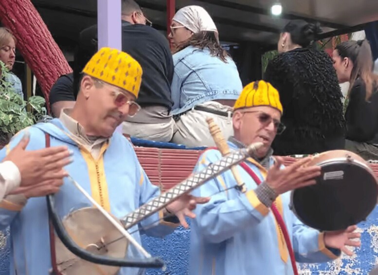 Two individuals in traditional attire playing stringed instruments. 2