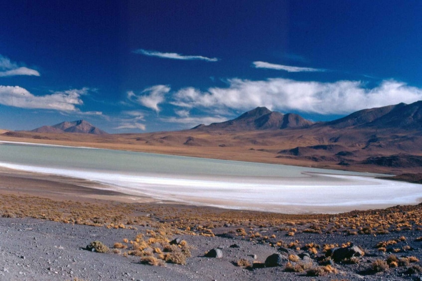 A salt flat with mountains in the background. 4