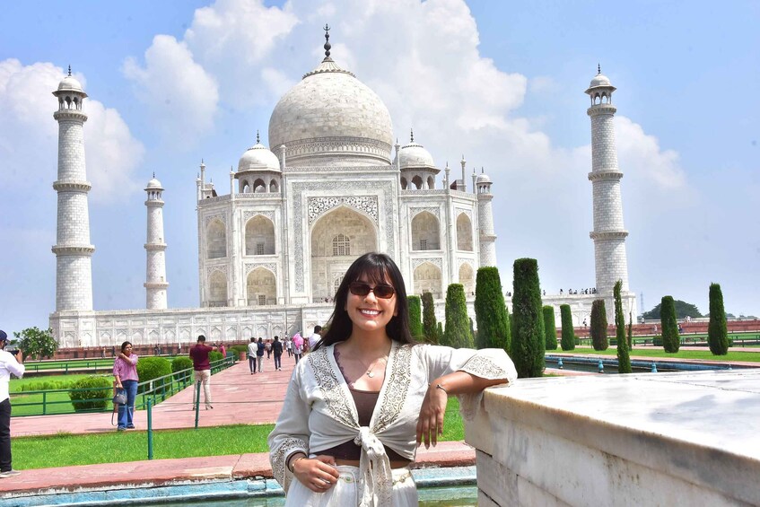 A person standing in front of the Taj Mahal with its iconic domes and minarets. 2