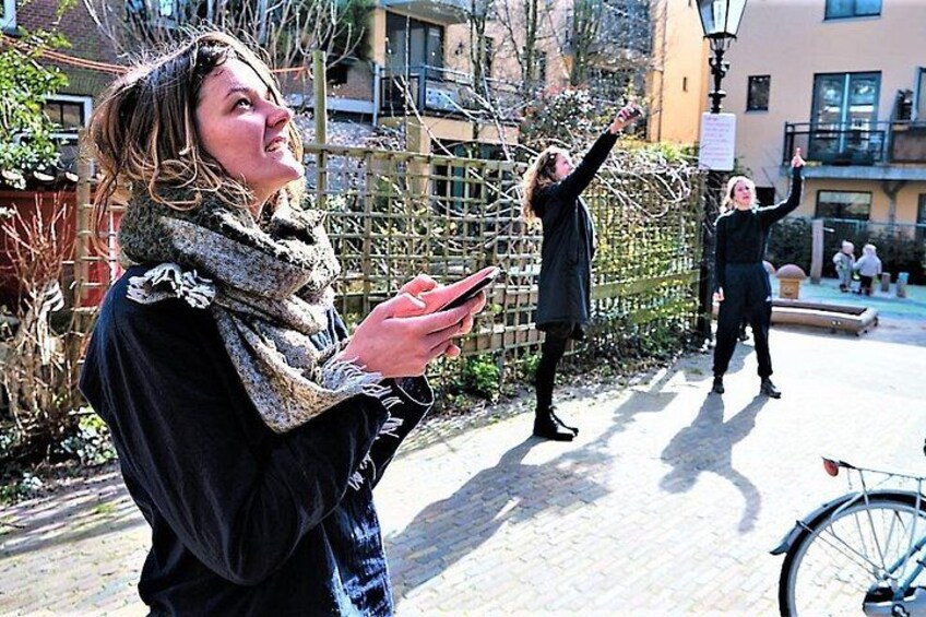 Une personne tenant un téléphone intelligent, une autre personne prenant une photo et un vélo, le tout dans un environnement urbain extérieur. 5