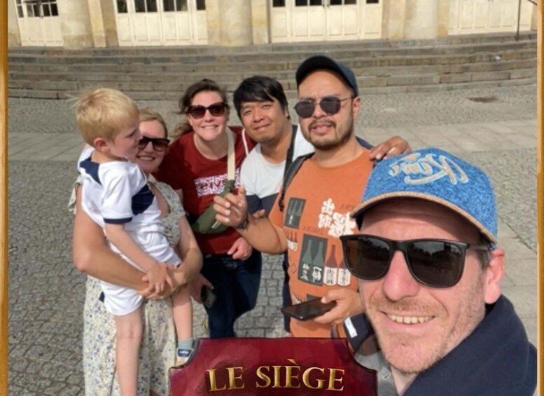 A group of people outdoors with a building in the background. 4