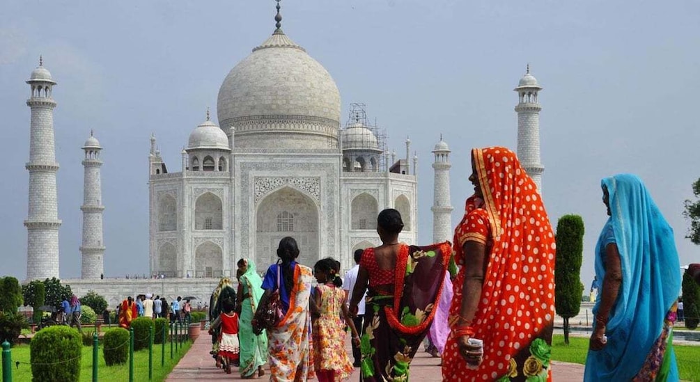 The Taj Mahal with visitors in colorful traditional attire. 5