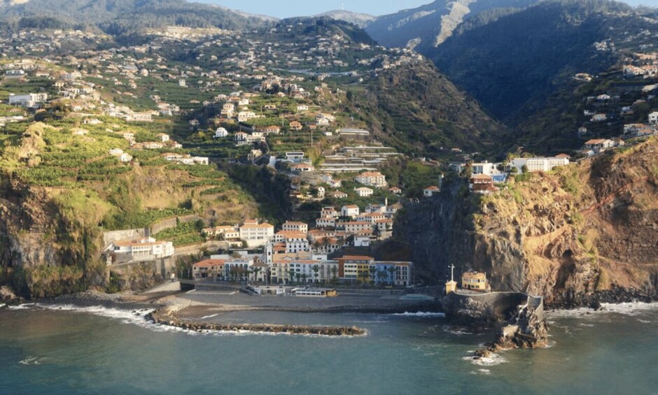 A coastal town with buildings perched on a hillside overlooking the sea. 3