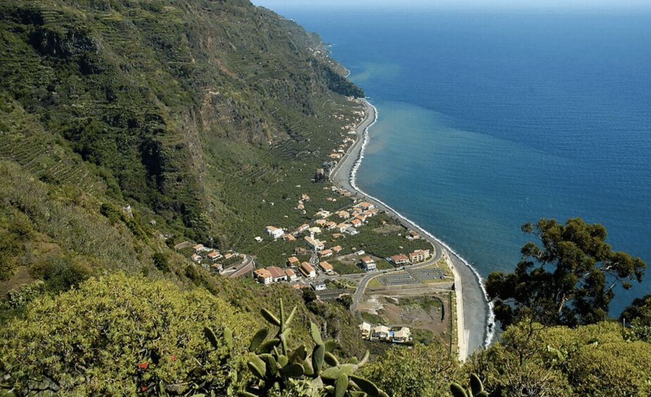 A coastal town with terraced houses along the hillside and a road leading to the beach. 4