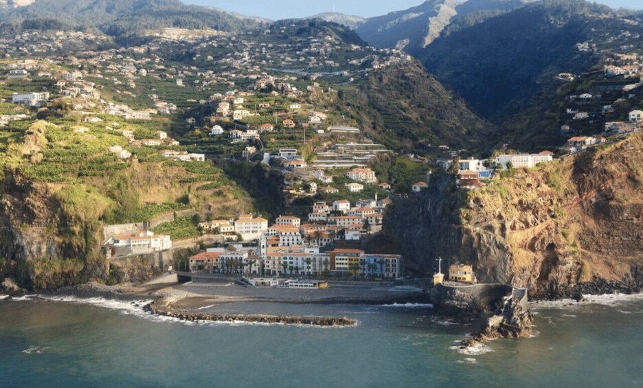 A coastal town with buildings on a hillside overlooking the sea. 1