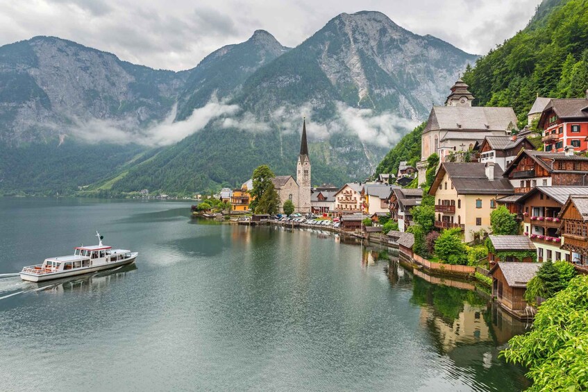 A lakeside village with traditional houses, a church, and mountains in the background. 5