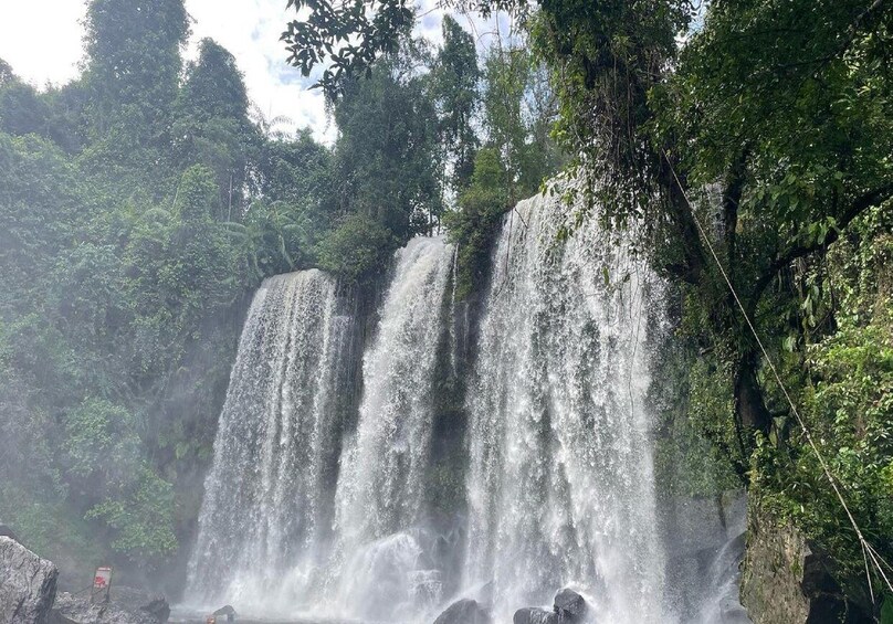A waterfall cascading down a rocky cliff surrounded by lush greenery. 3