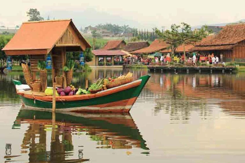 A traditional boat with a thatched roof docked at a riverside village. 4