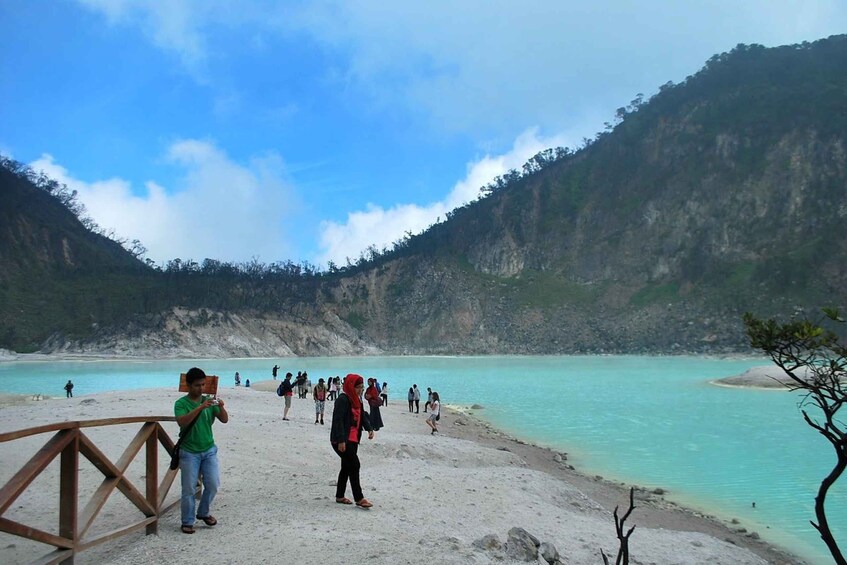 A coastal area with a wooden walkway, turquoise waters, and a mountainous backdrop. 5