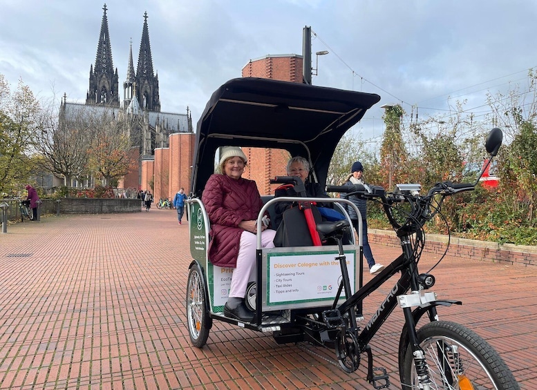 A person riding a bike with a trailer in front of a cathedral. 5