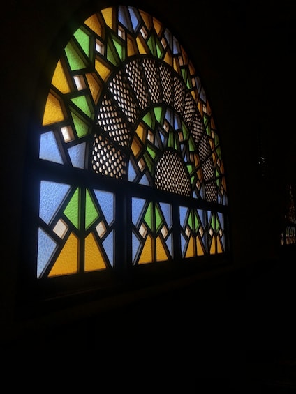 A stained glass window with geometric patterns and vibrant colors. 1