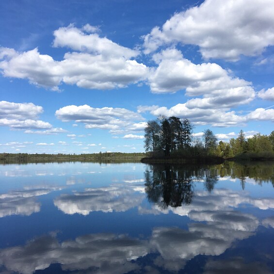 A calm lake reflecting trees and clouds. 5