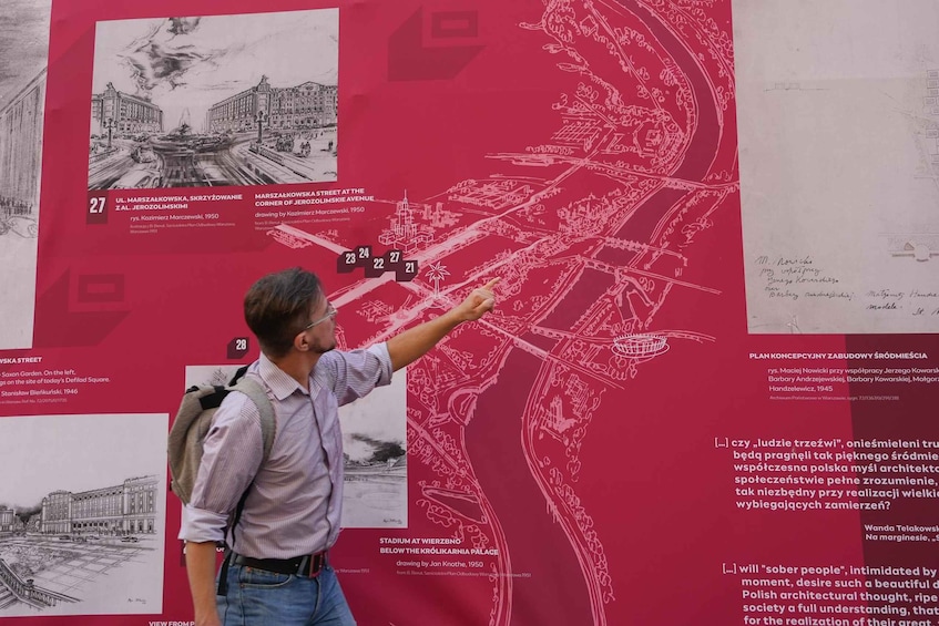 A man pointing at a detailed map of a city street with various landmarks and buildings. 3